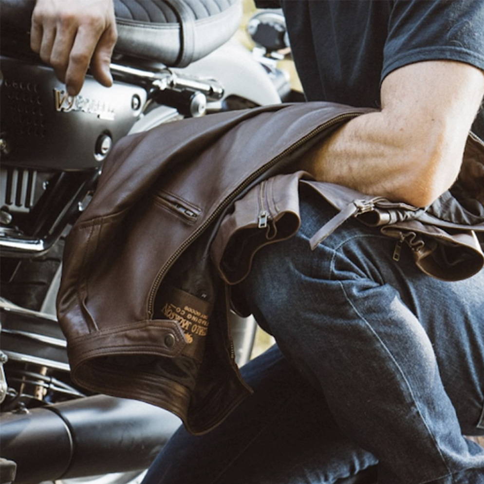 man holding a leather jacket